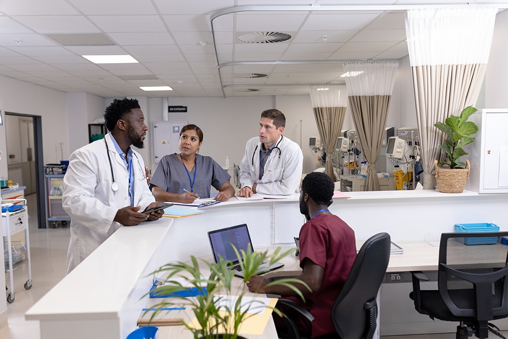 Diverse doctors and medical staff talking at reception desk of hospital ward. Hospital, teamwork, medical and healthcare services.